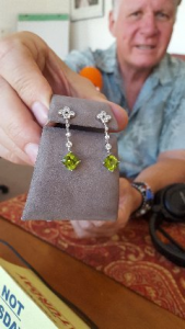 Steve Kanold holding diamond/peridot earrings
